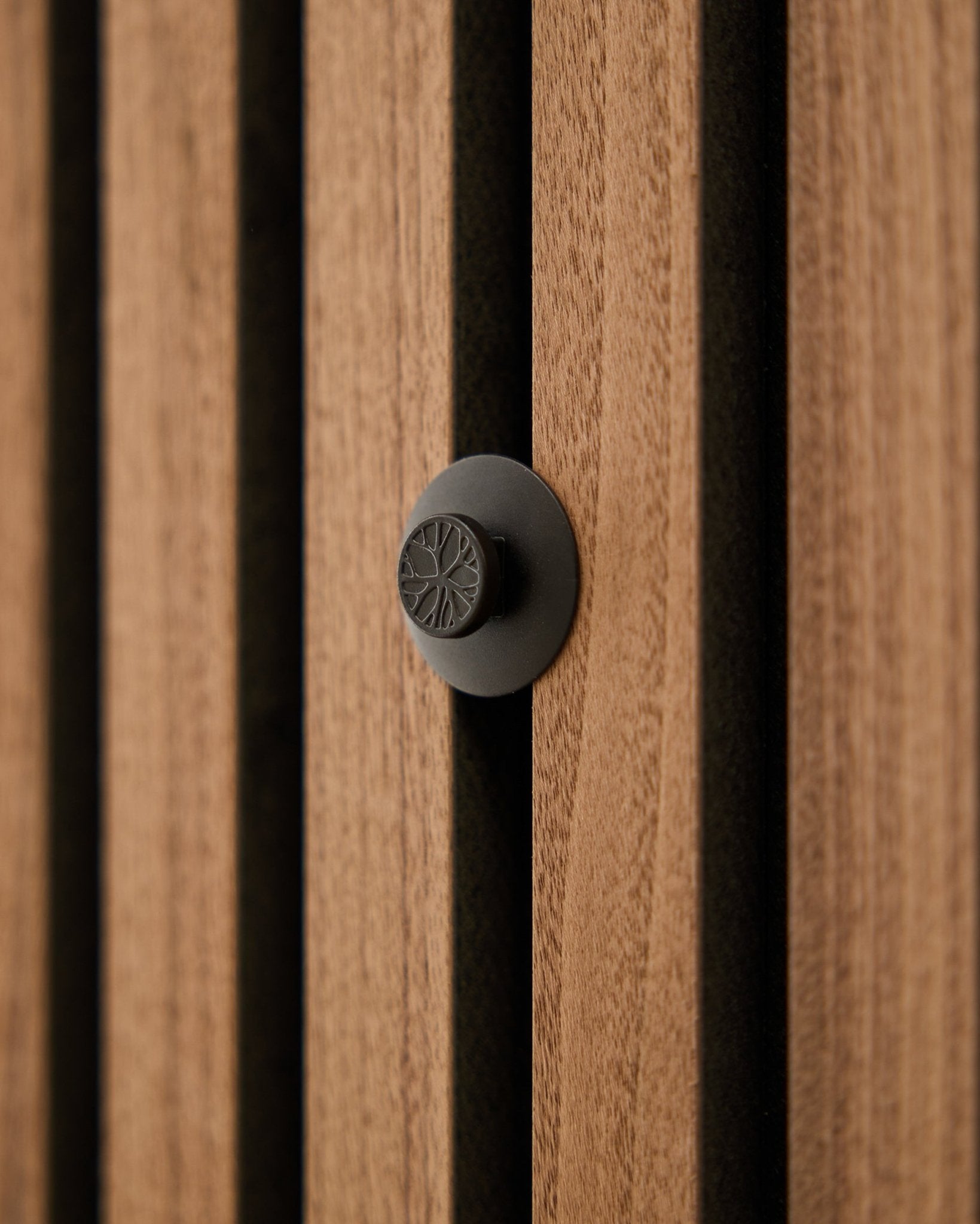 Close-up van een ronde black knop uit de WoodUpp Dupps Original set, gemonteerd op een moderne vertical Akupanel akoestische houten lattenwand.
